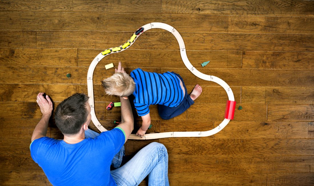 Image showing father and son playing on a wood floor.