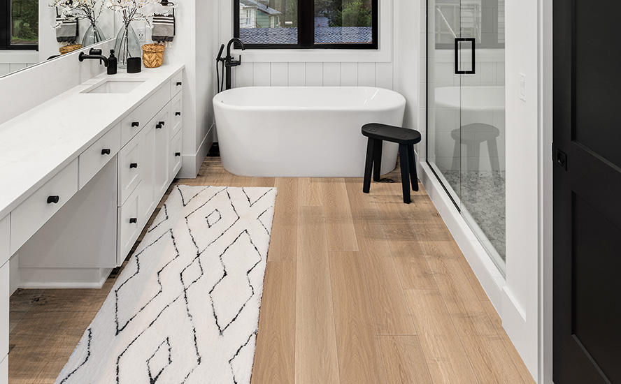 Image showing Johnson Hardwood flooring in a master bathroom interior in new farmhouse style luxury home large mirror, shower, and bathtub. Master bathroom with double vanity